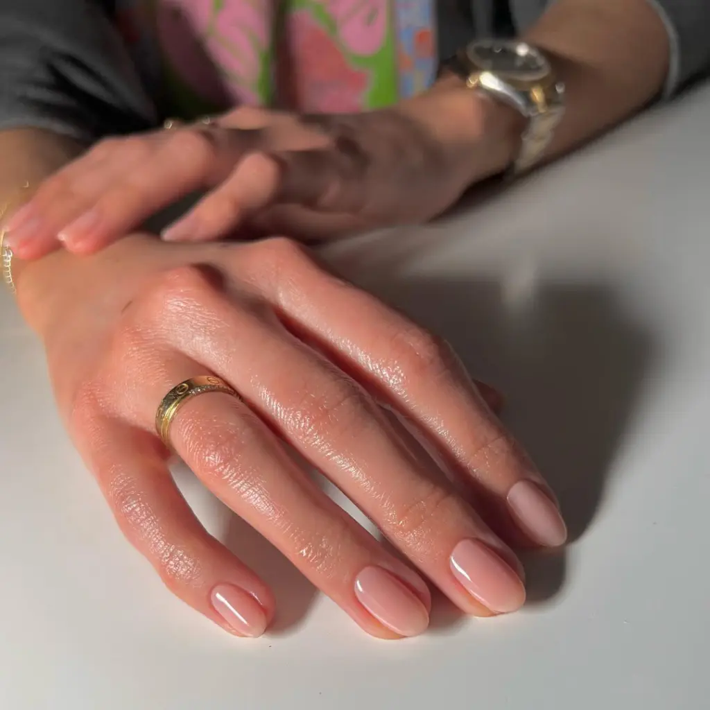 Sheer nude neutral nails on short oval shape with natural finish