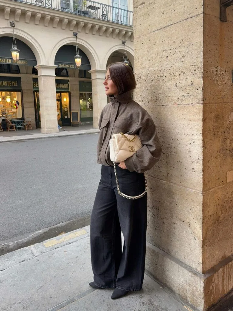Everyday autumn outfit with brown wool jacket, black wide-leg jeans, and cream quilted shoulder bag
