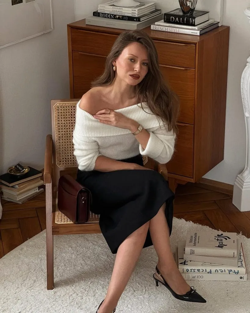 Chic old money outfit with cream off-shoulder sweater, black midi skirt and slingbacks