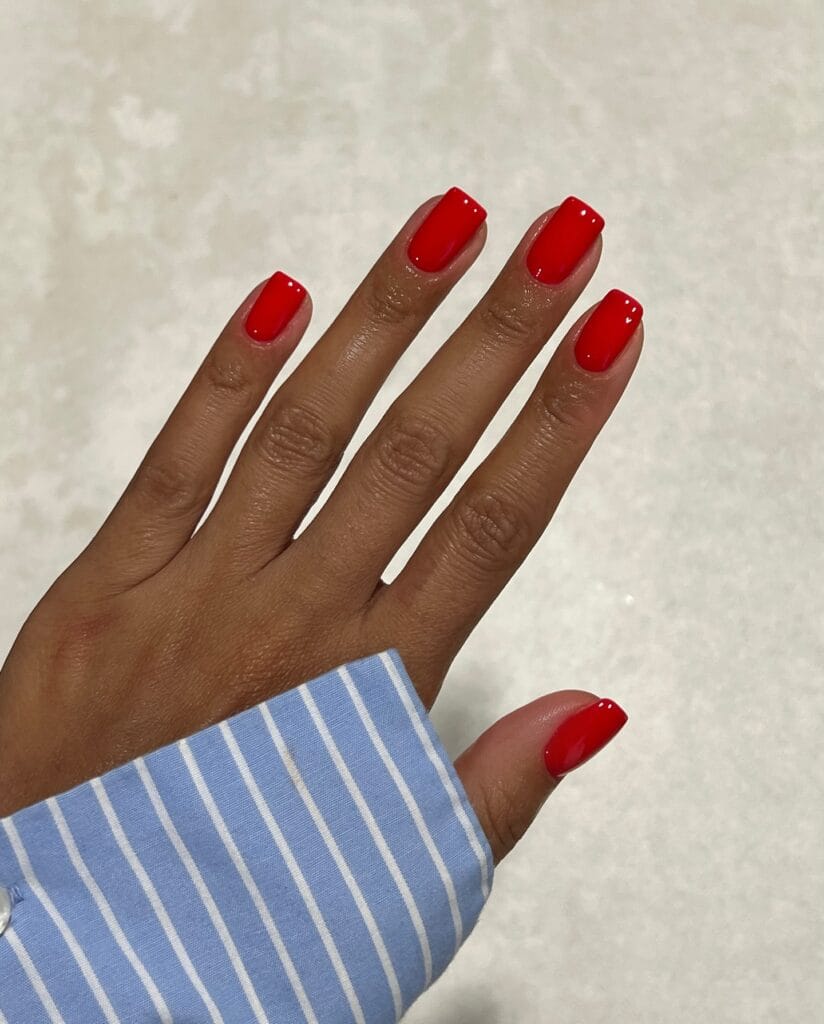 Glossy bright red nails with short square tips for a classic fall manicure.
