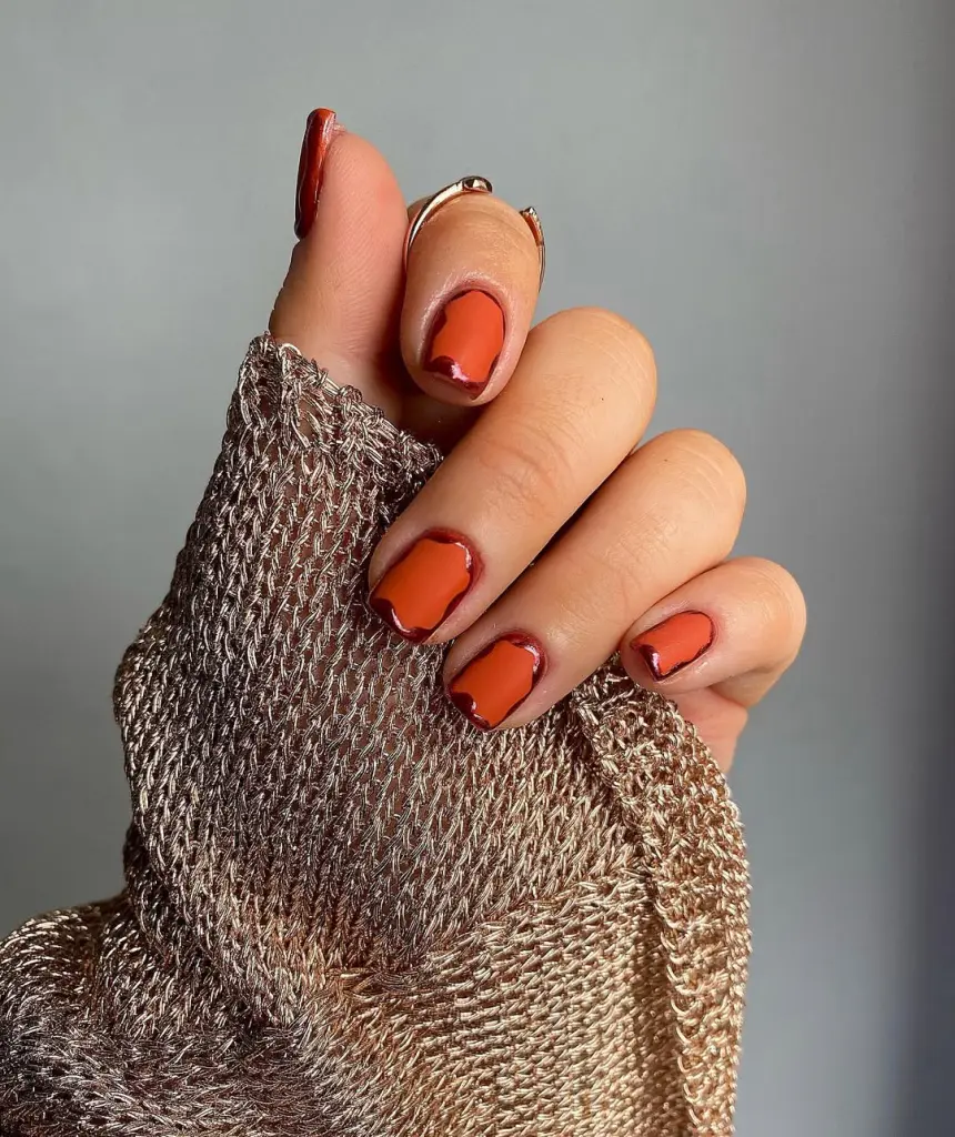 Short fall nails in matte orange with burnt orange chrome curved outline details and square shape
