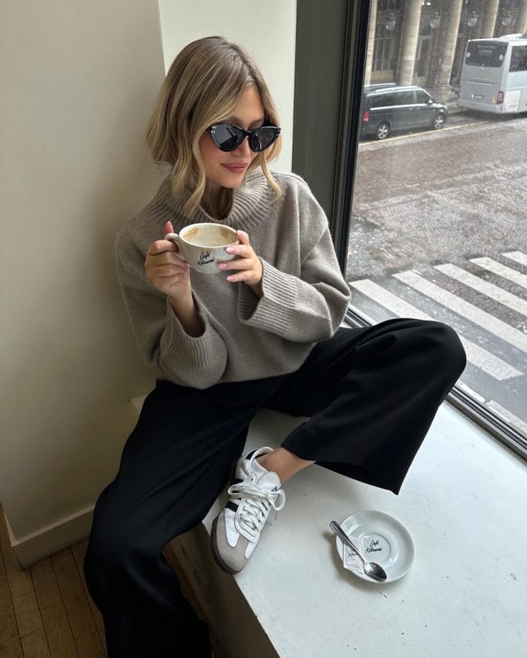Casual fall outfit with taupe oversized turtleneck sweater, black wide-leg pants, white sneakers
