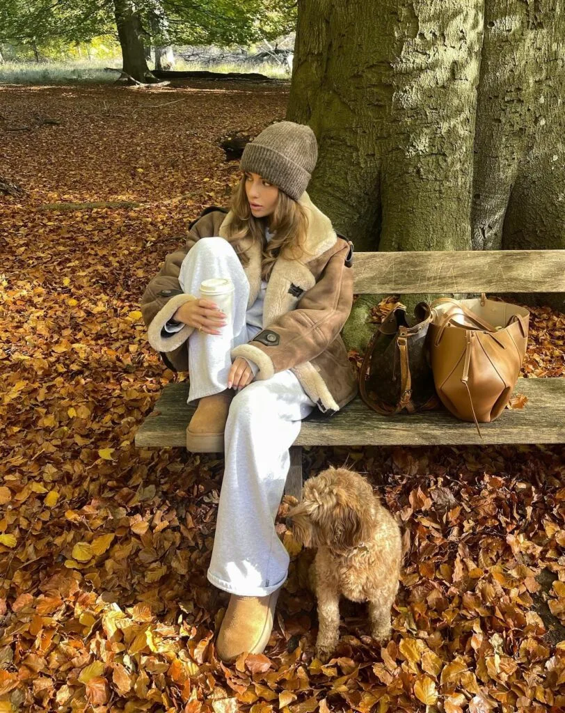 Cozy fall outfit with tan shearling jacket over white sweatsuit, gray ribbed beanie and tan Ugg boots
