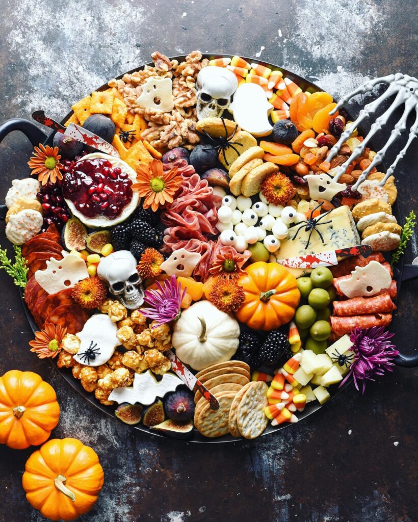 Halloween charcuterie board with skulls and skeleton decorations
