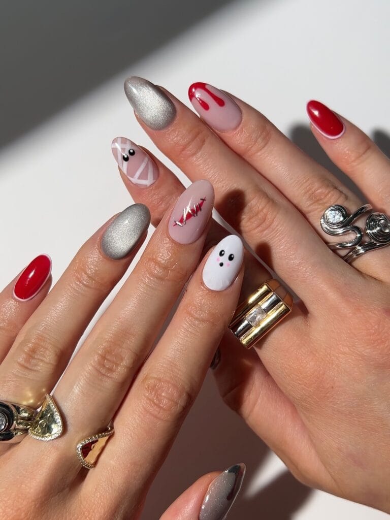 mix and match Halloween nails with ghost, mummy, stitches and blood drip accents, red and silver shimmer
