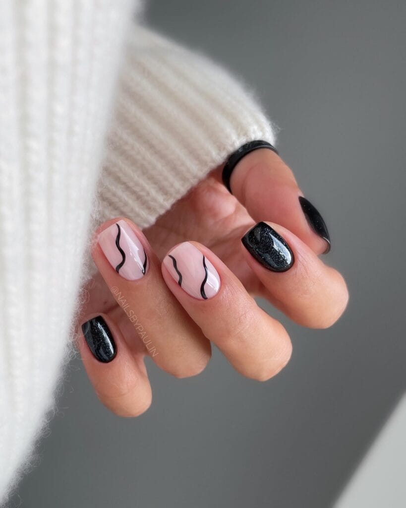 short nails with milky base and black squiggle design, alternating with black glitter nails, Halloween nail art