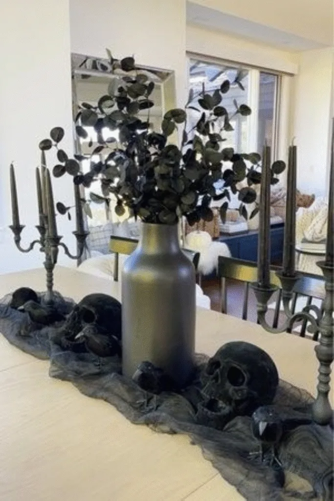 Black skull Halloween decorations with eucalyptus centerpiece on table