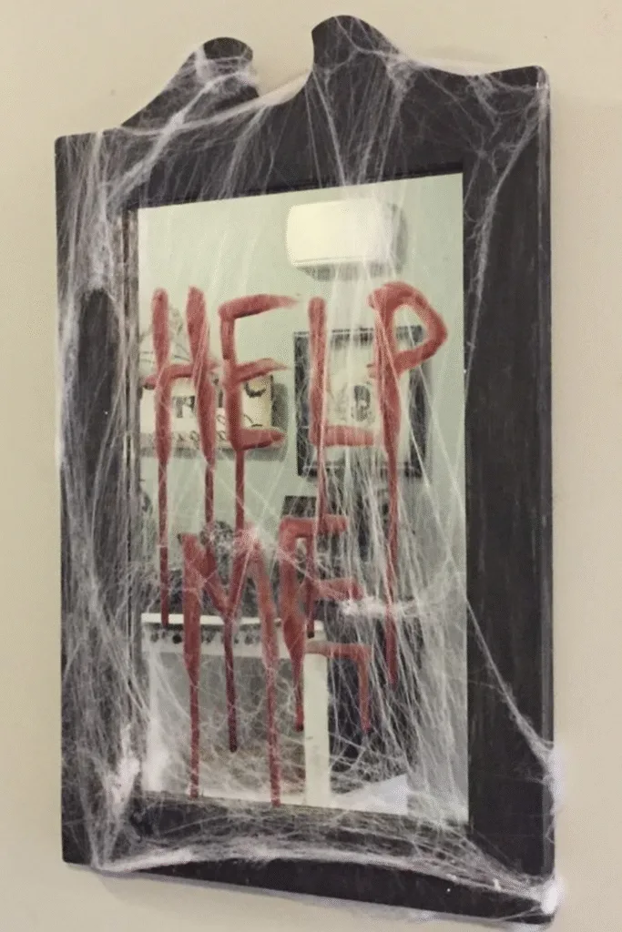 Halloween decorations with help me mirror message and spider webs