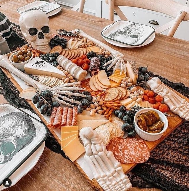Halloween charcuterie board table setting with skeleton hands