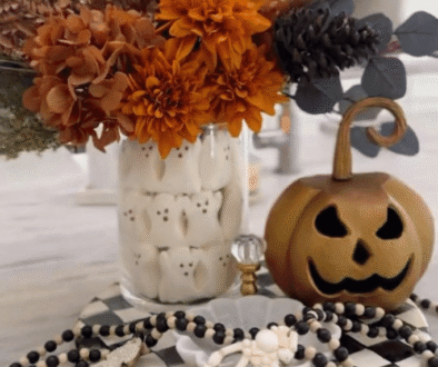 Skull vase Halloween decor with fall flowers and skeleton hands