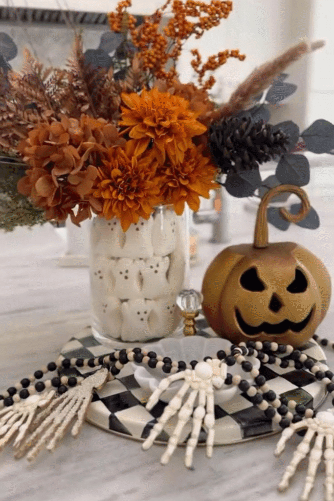 Skull vase Halloween decor with fall flowers and skeleton hands