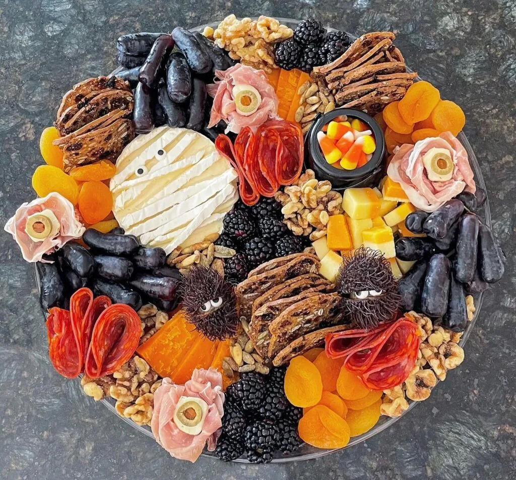 Halloween charcuterie board with mummy brie and cookie spiders