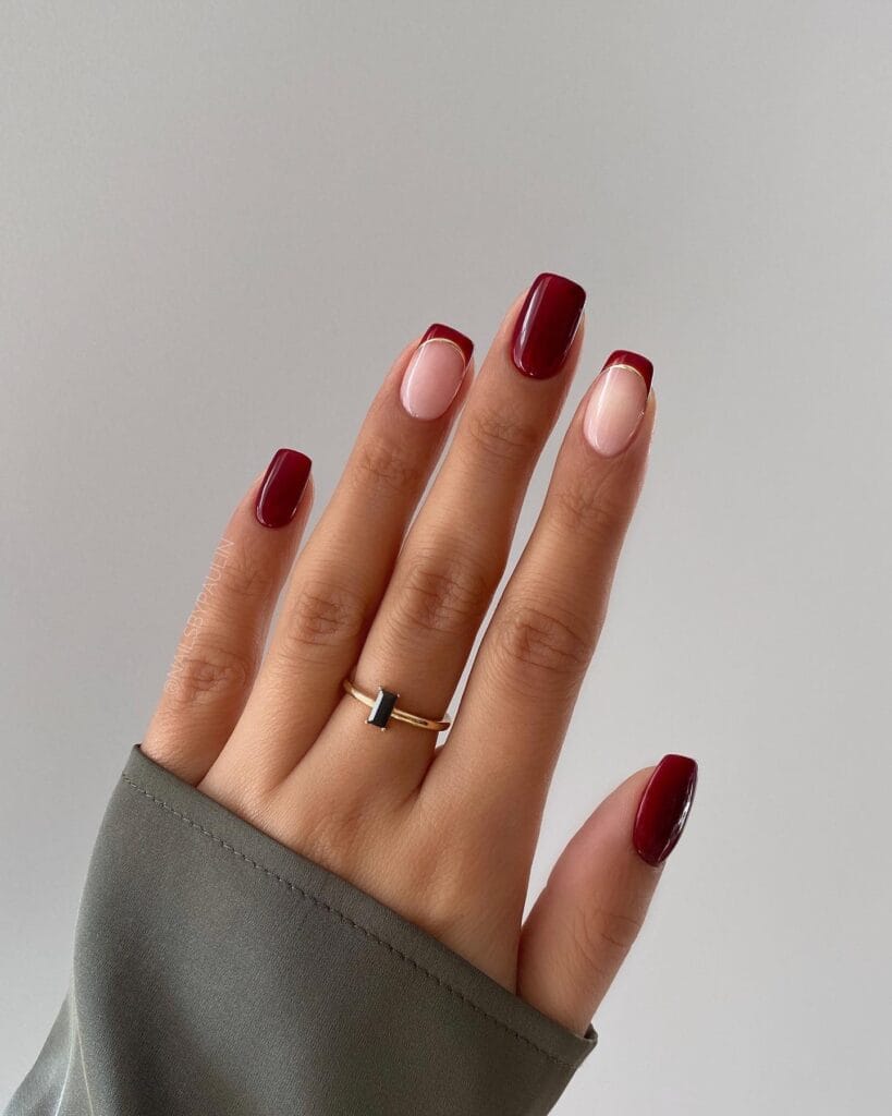 Burgundy French tip nails with mix of nude and solid burgundy