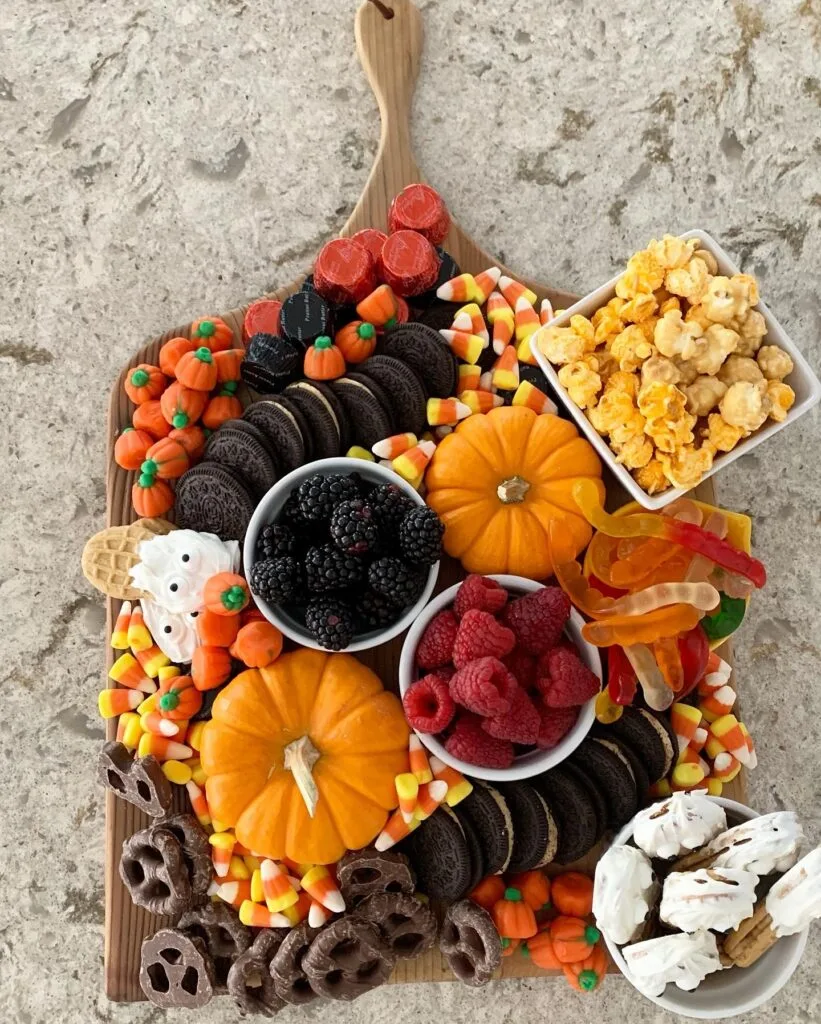 Halloween charcuterie board with candy and mini pumpkins