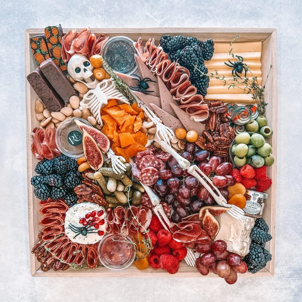 Halloween charcuterie board with skeleton lying across snacks