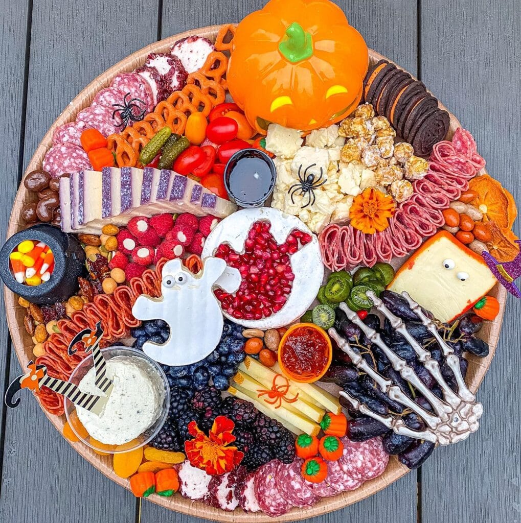 Halloween charcuterie board with ghost brie and skeleton hand decorations