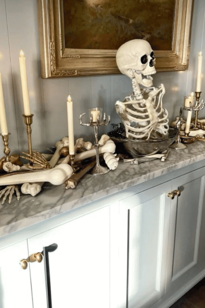 Skeleton Halloween decorations with bones and candles on sideboard