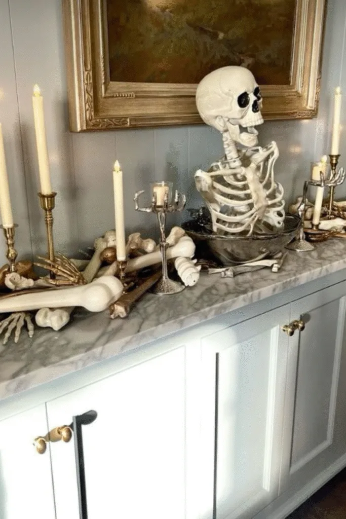 Skeleton Halloween decorations with bones and candles on sideboard