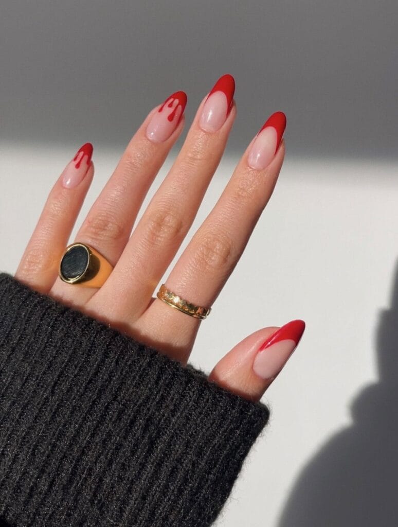 red French tip almond nails with blood drip accents on a sheer nude base, Halloween nails

