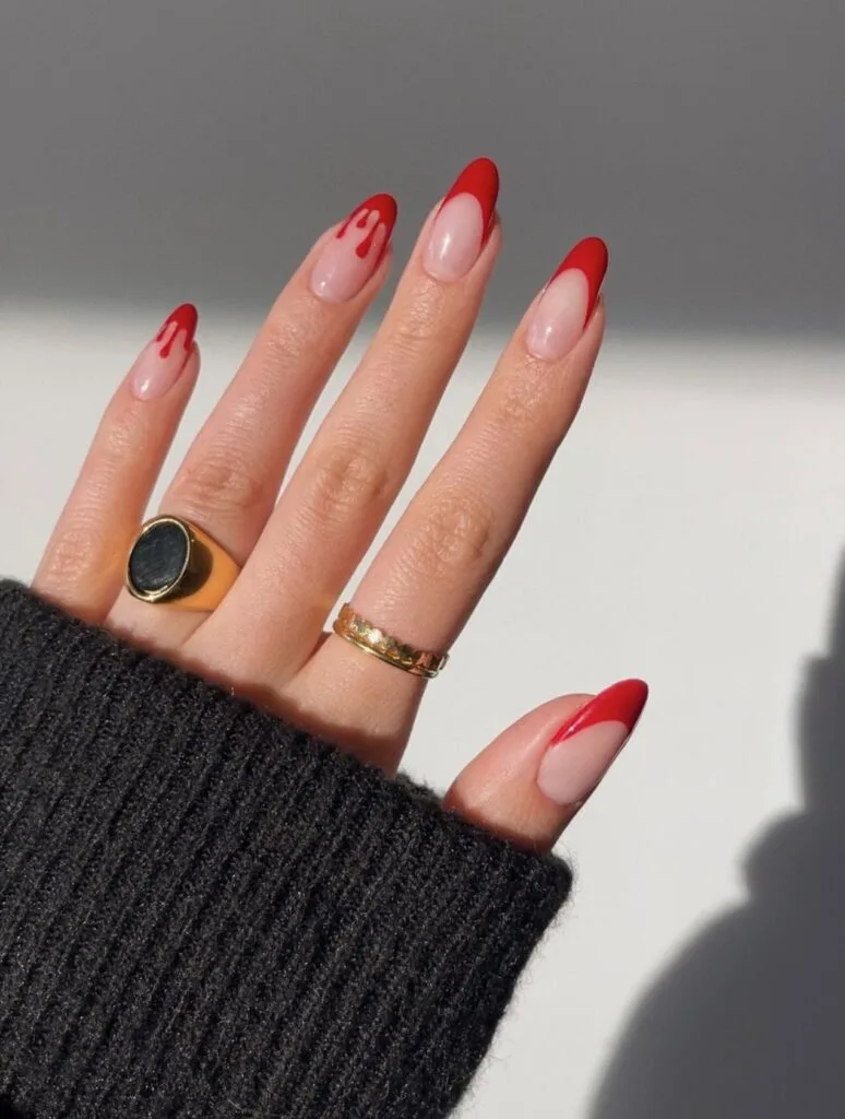 red French tip almond nails with blood drip accents on a sheer nude base, Halloween nails
