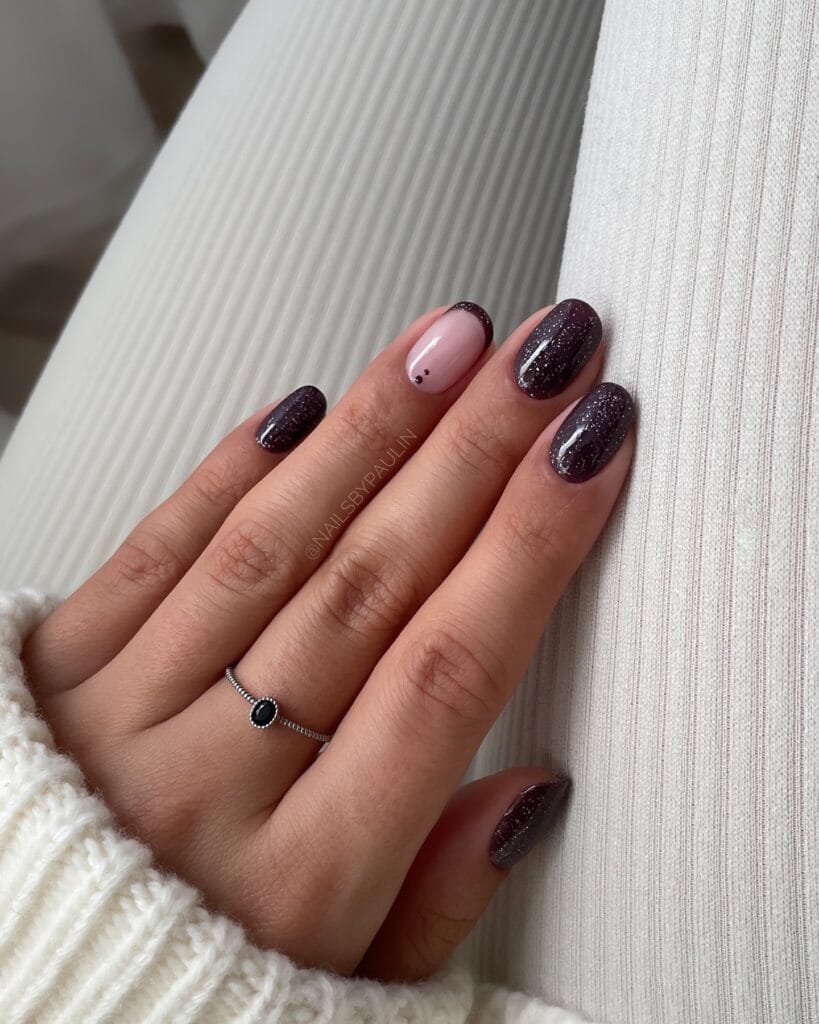 almond nails with black glitter polish and blush accent nail with tiny dots, fall nail ideas