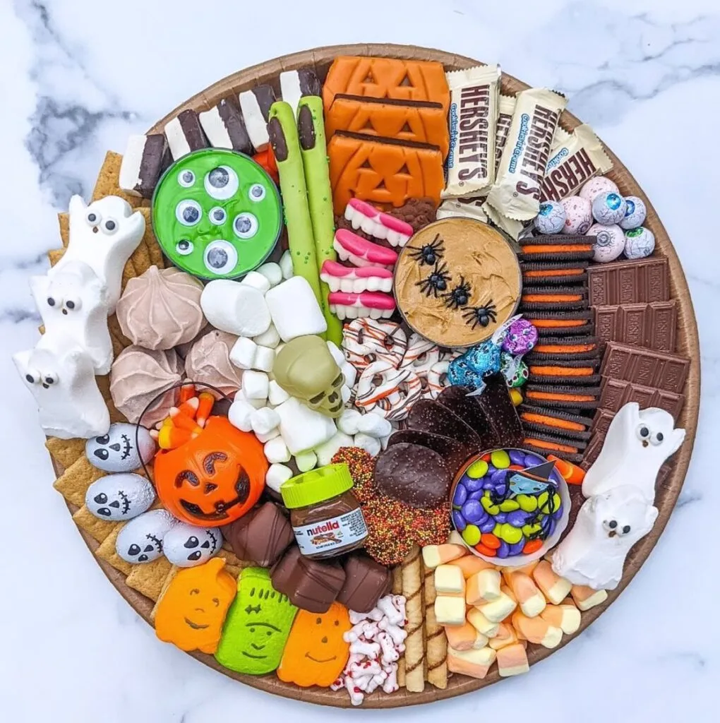 Halloween charcuterie board with monster cookies and candy