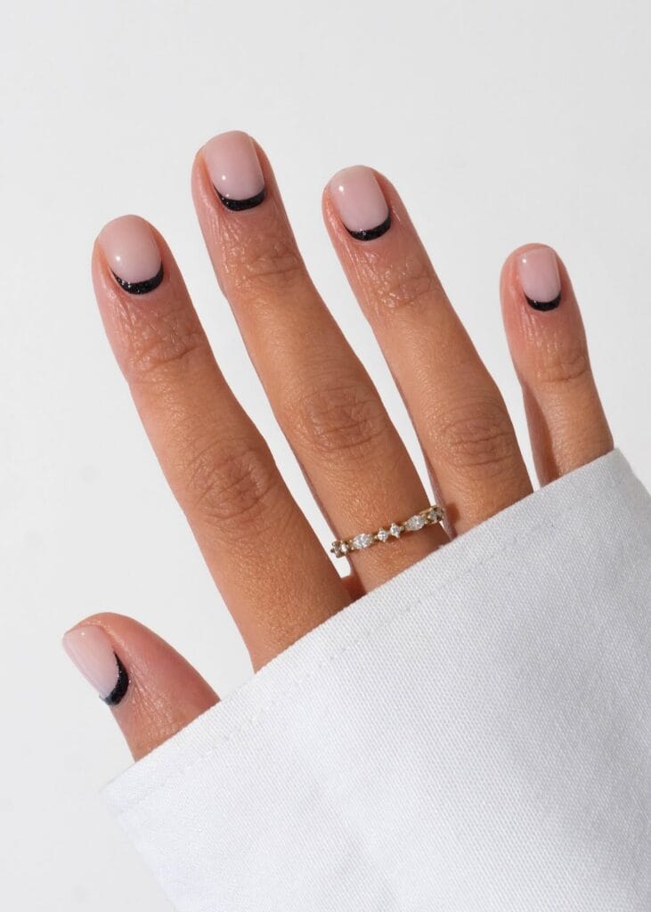 short nails with nude base and black glitter reverse French design, October nail ideas