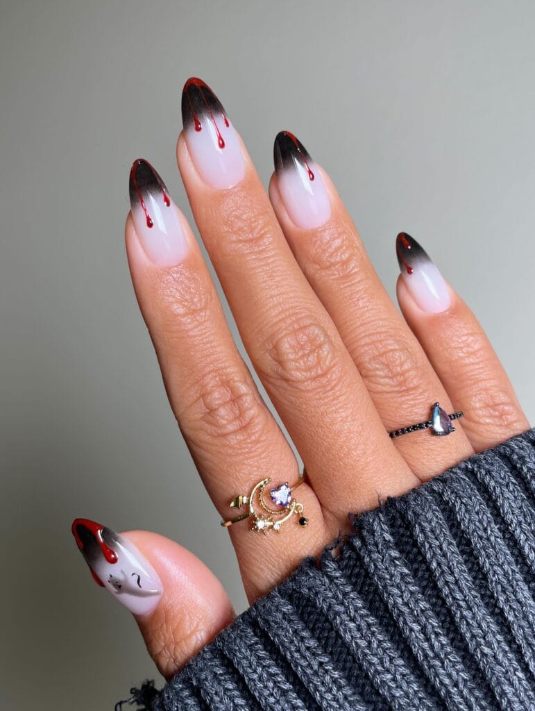 ong milky almond nails with airbrushed black tips and red blood drips, Halloween nail art
