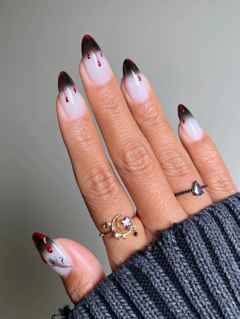 ong milky almond nails with airbrushed black tips and red blood drips, Halloween nail art
