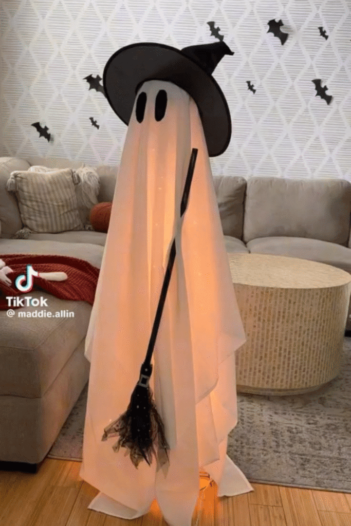 Glowing ghost Halloween decoration with witch hat and wall bats