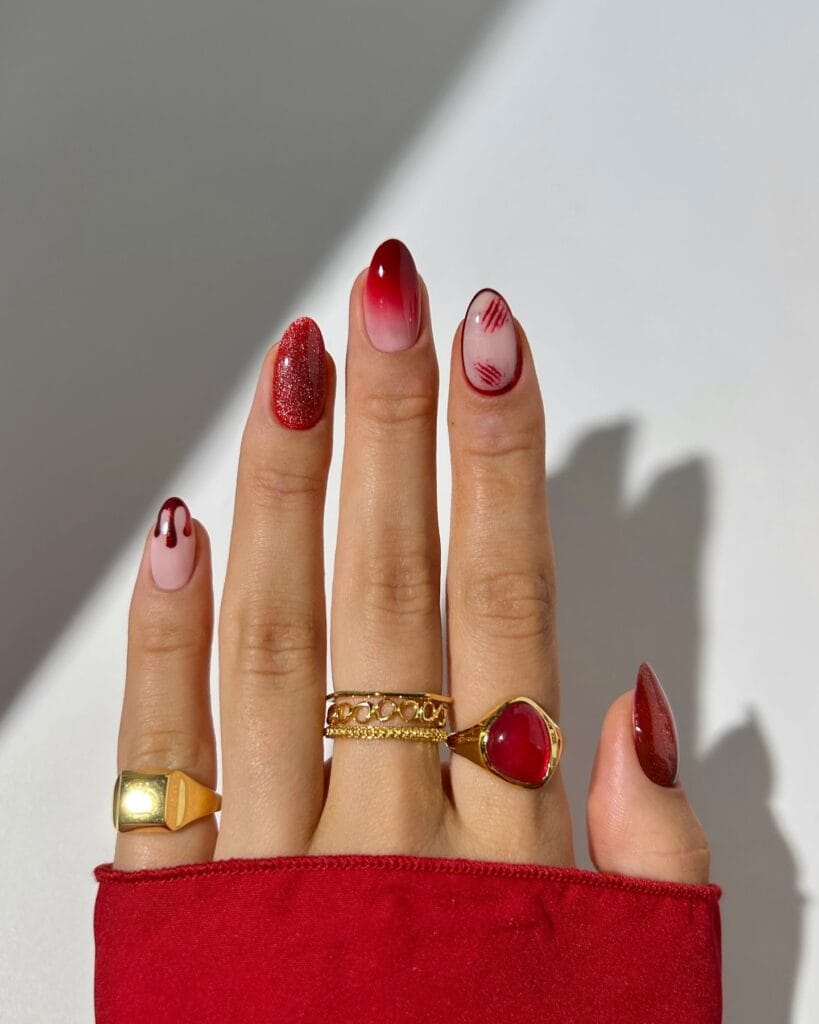 mismatched red Halloween nails with claw scratch accent, red ombré, glitter and drip details
