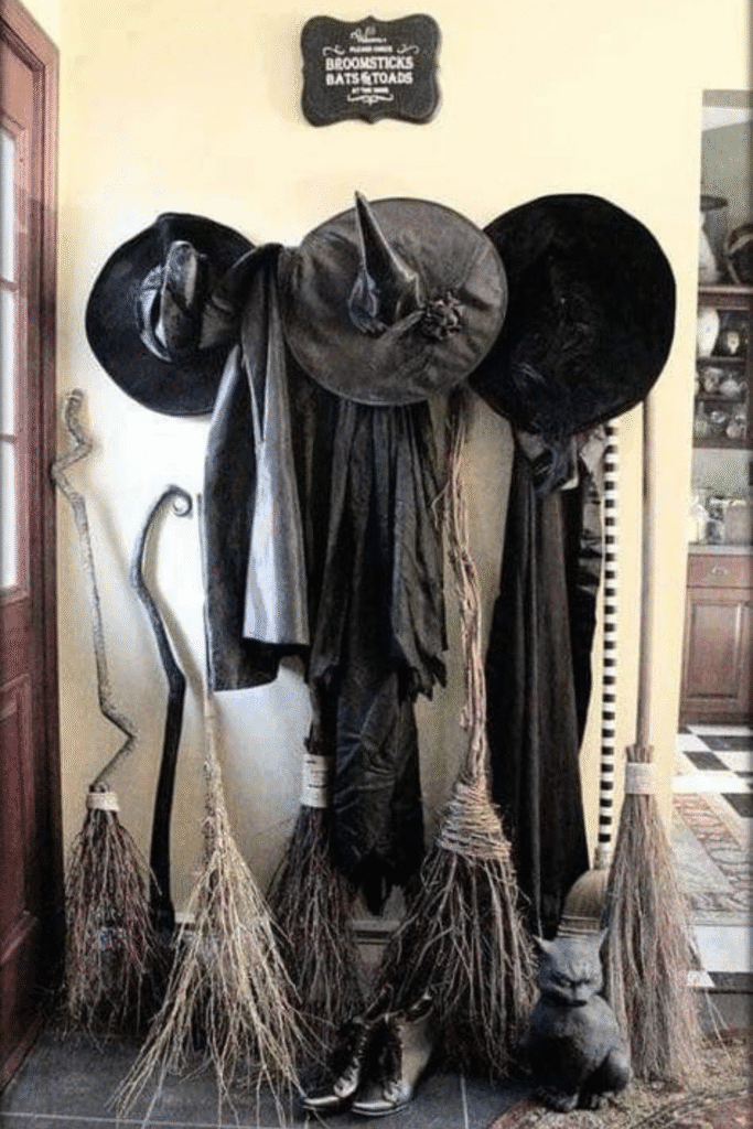 Witch hats and brooms Halloween decorations hanging on wall