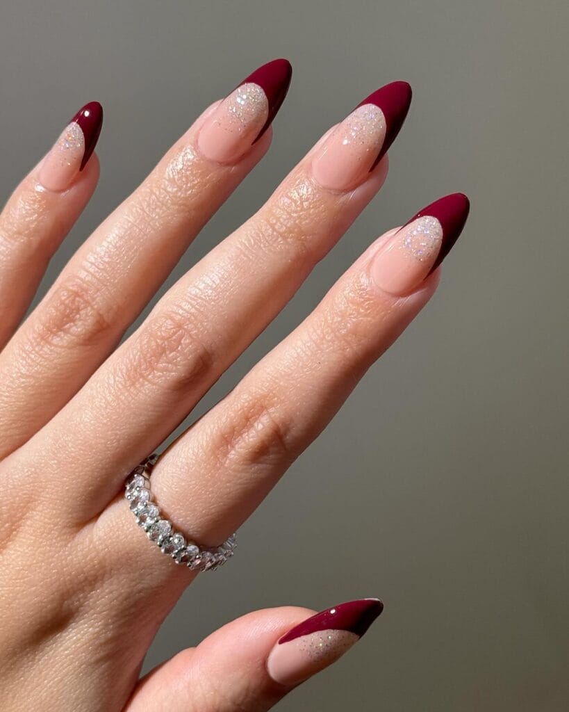 Deep berry French tips with glitter on almond nails" winter nail trends, frosted French