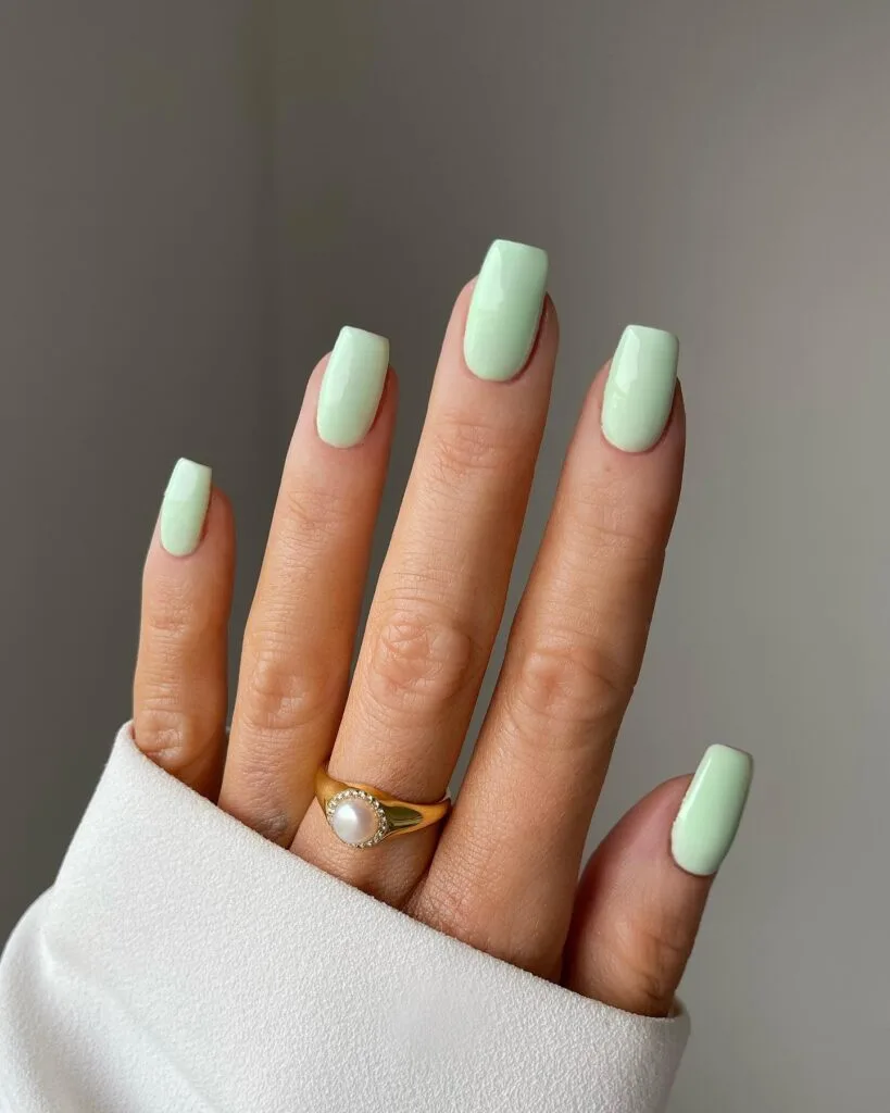 glossy mint green manicure on medium square nails; simple winter nails in pastel green.
