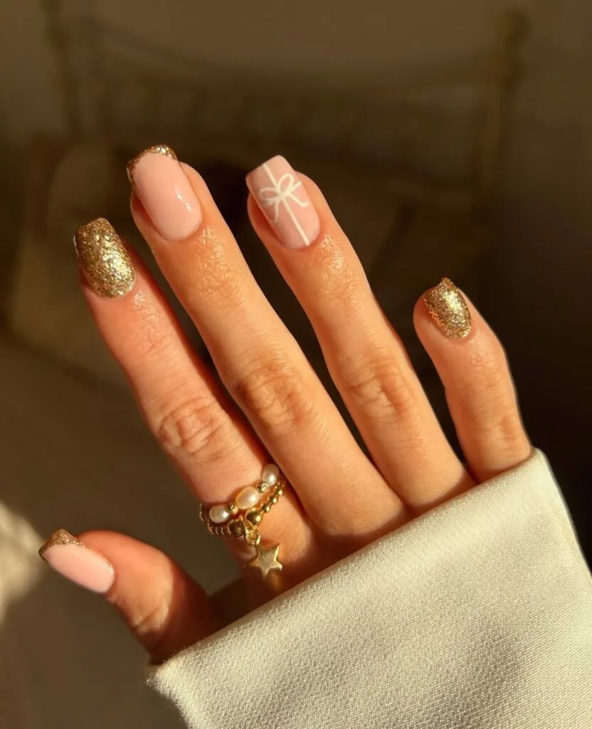 nude and gold glitter nails with white gift bow art, Christmas nails