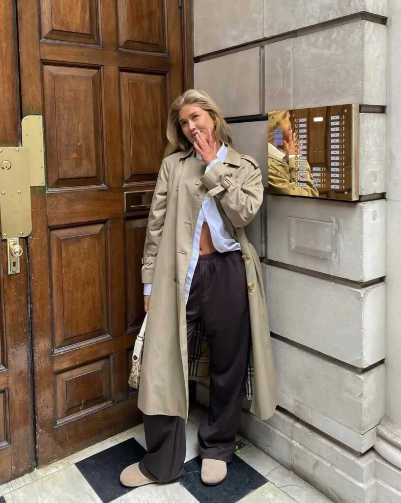 Beige trench over white button-down and chocolate wide-leg pants with tan clogs—casual winter outfits.
