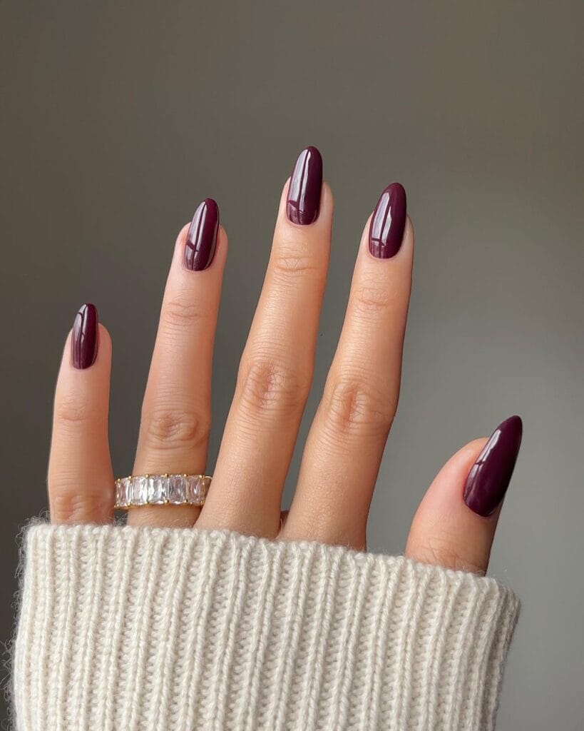 January nails in glossy deep burgundy on almond-shaped nails.
