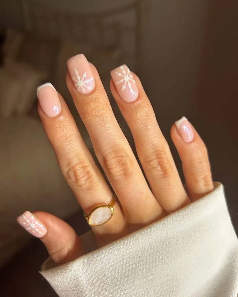 pale pink French tips and white snowflake nail art; simple winter nails inspiration.