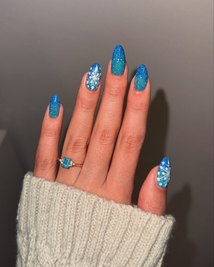bright blue glitter nails with white snowflake art, winter Christmas nails