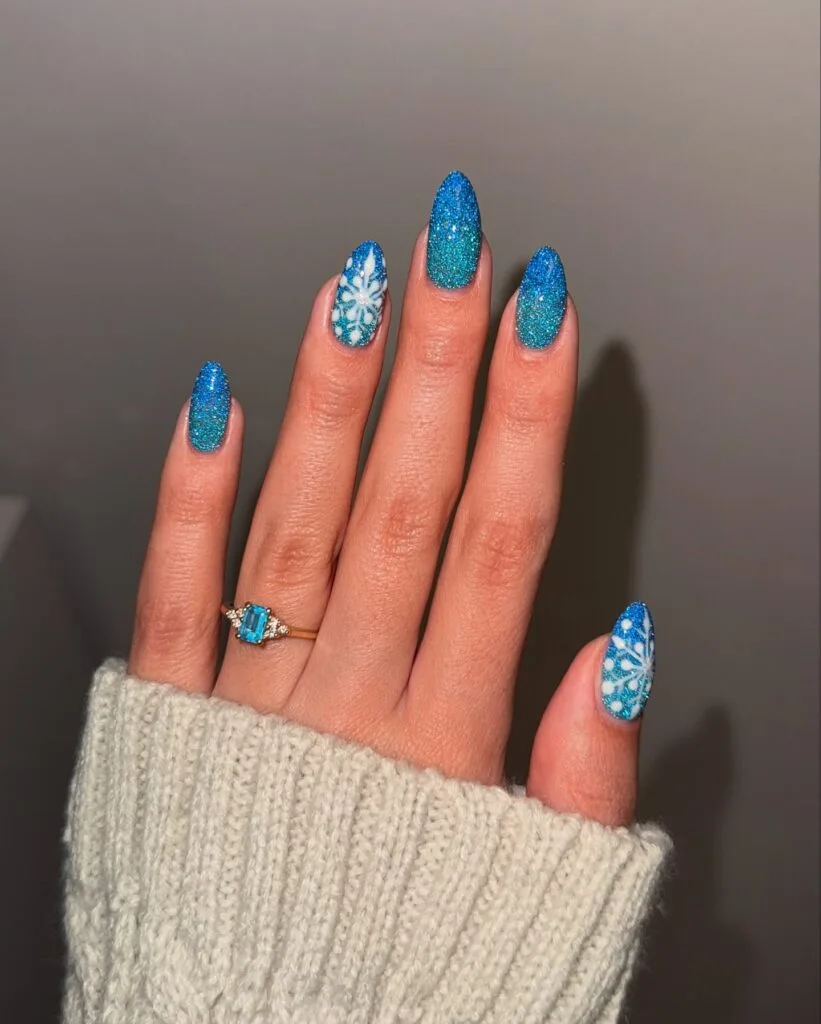 bright blue glitter nails with white snowflake art, winter Christmas nails