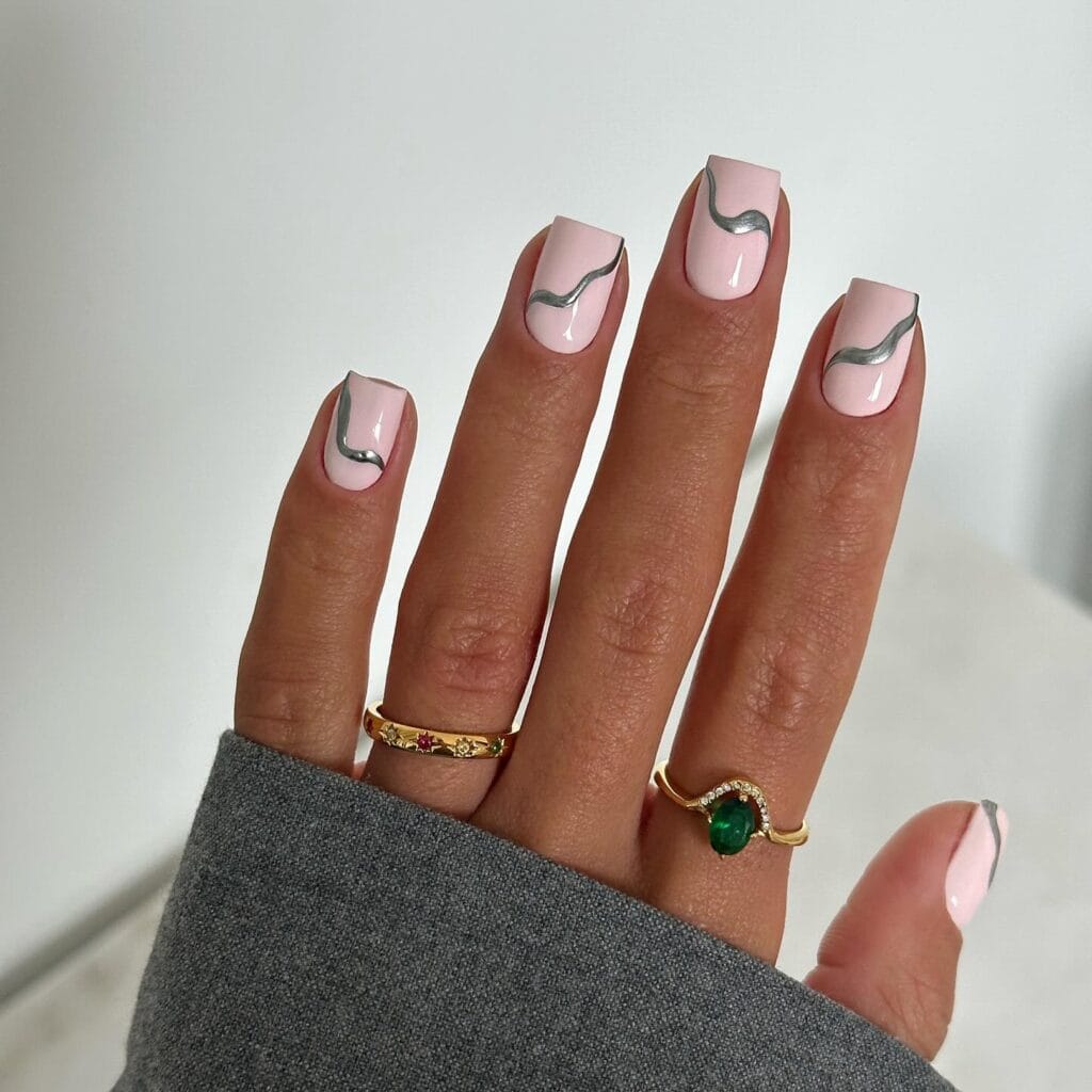 short winter nails, pink base with metallic silver abstract wave lines, square shape, gold rings