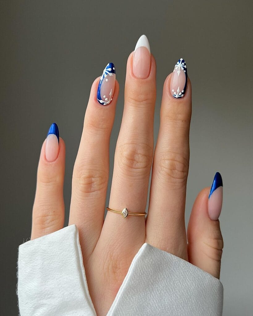 January nails with cobalt blue and white French tips plus a blue snowflake accent on almond nails.
