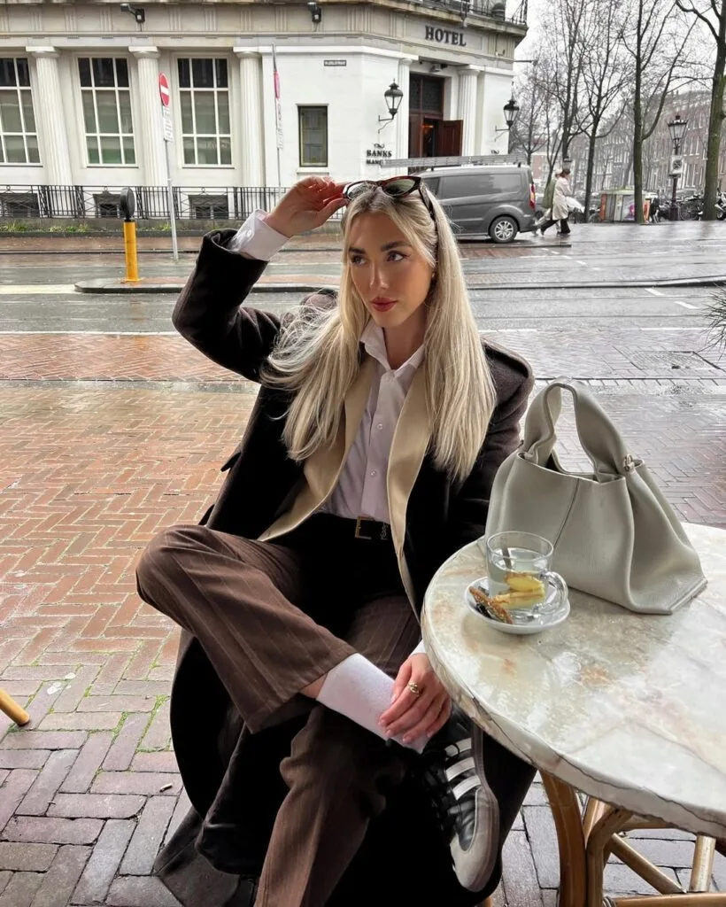 winter work outfit with brown blazer and trousers, white shirt, light vest, white socks, sneakers, sunglasses
