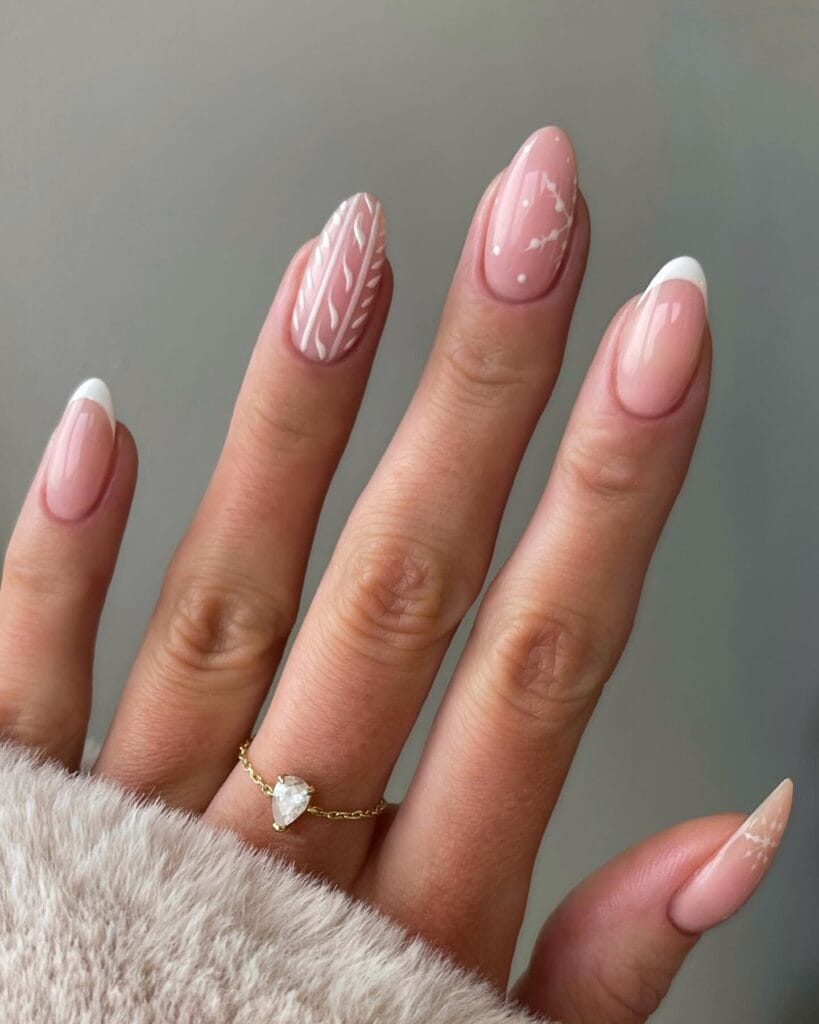 January nails with blush pink French tips and white leaf line art on almond nails.
