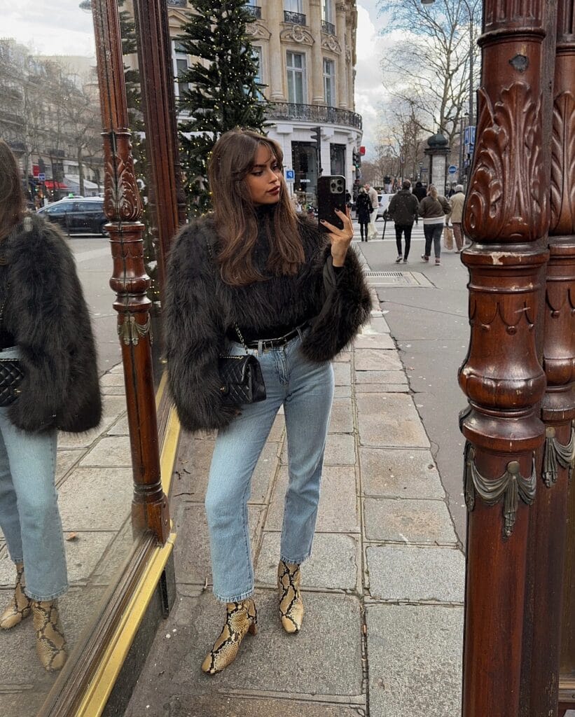 black faux fur jacket, blue jeans, and snakeskin boots, winter paris winter outfit
