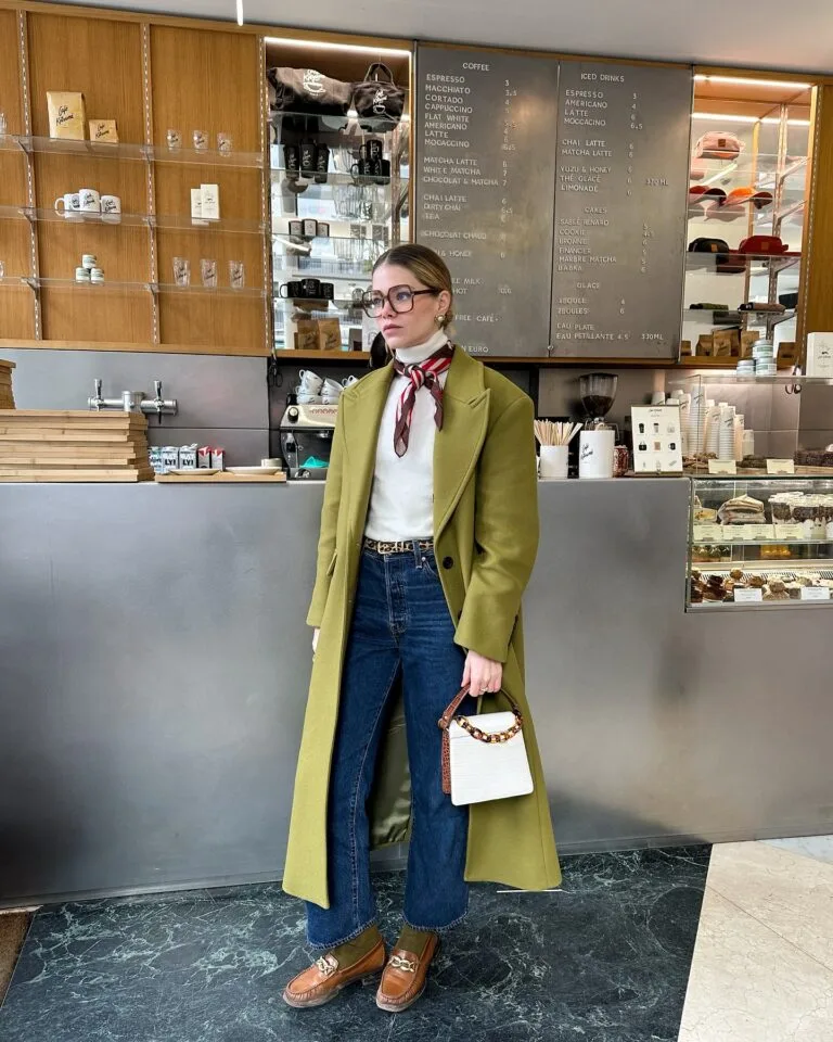 olive green coat, red scarf, white turtleneck, jeans, and loafers, winter paris outfit