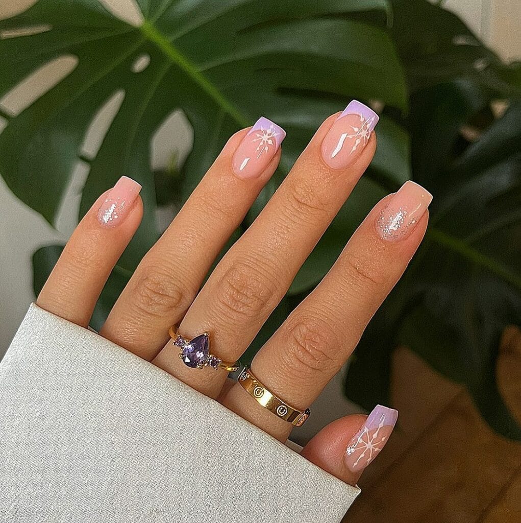 nude nails with lavender French tips, white snowflake art, and shimmer, winter nails
