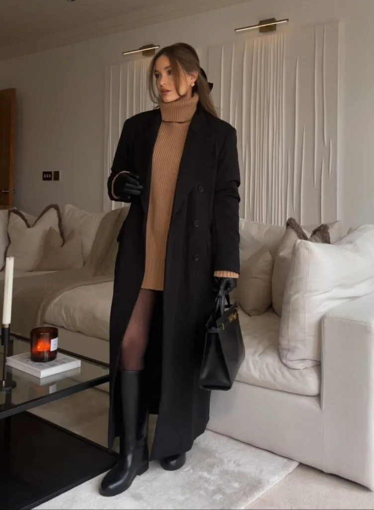 woman wearing black coat, camel ribbed turtleneck sweater dress, black boots, black gloves, effortlessly chic winter outfit