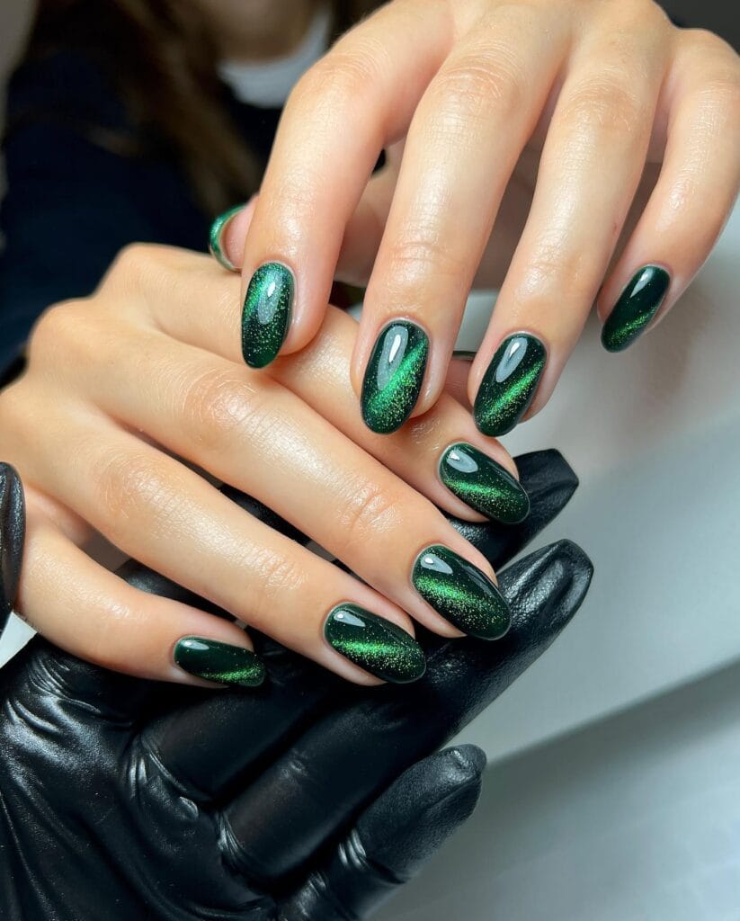 Emerald green velvet cat-eye nails with shimmer" winter nail trends, velvet luxe finish