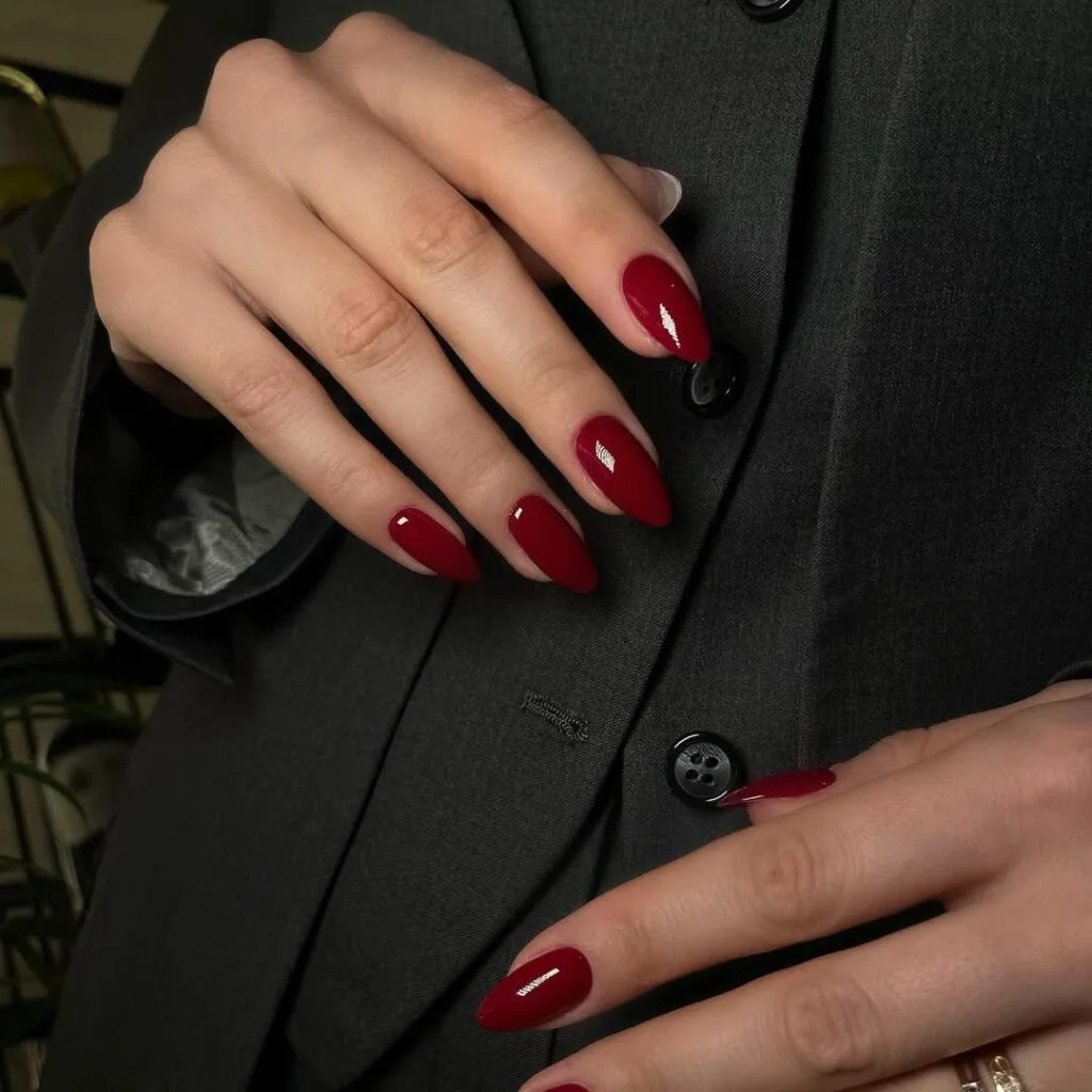 Simple winter nails in glossy burgundy on almond-shaped nails.